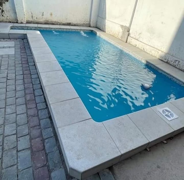 Piscina terminada con revestimiento azul y bordes de baldosa