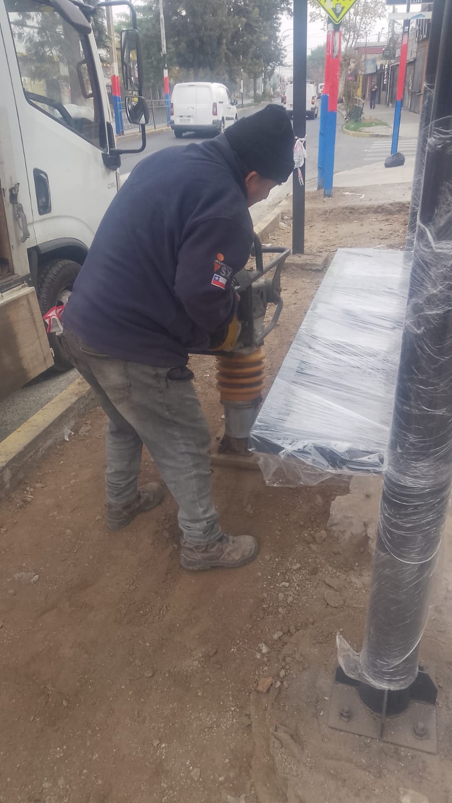 Trabajador de Constructora LTC compactando terreno junto a un paradero